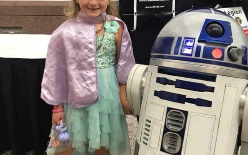 little girl cosplaying with R2D2